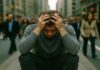 Man experiencing panic attack in a crowded street showing anxiety symptoms and loss of control.